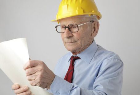 Builder - Senior male engineer reading blueprint in studio