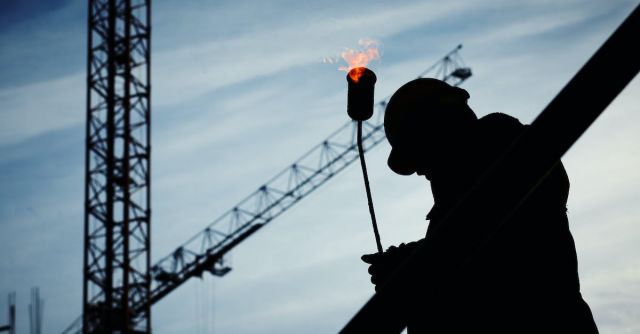 Construction Industry - Silhouette of Man Holding Flamethrower