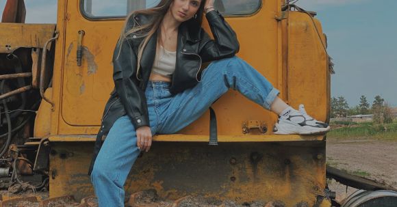 Bulldozer - Woman in Black Leather Jacket and Blue Denim Jeans Sitting on Yellow Bulldozer