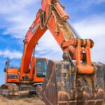Heavy Construction Equipment - Low Angle Photography of Orange Excavator Under White Clouds