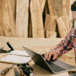 Construction Tools - Man Using a Laptop at a Wood Workshop