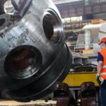 Construction Industry - Man Standing in Front of Gray Metal Machine Part