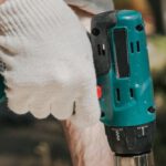 Construction - Person using Hand Drill on a Wooden Panel