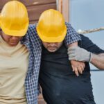 Construction Workers - A Worker Supporting an Injured Co-Worker