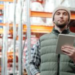 Loader - Man in Black Bubble Jacket Holding White Tablet Computer