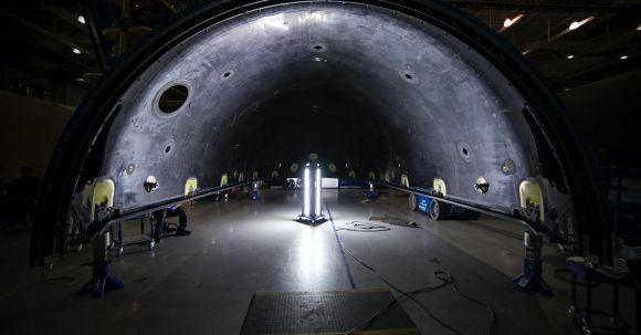 Heavy Construction Equipment - Illuminated tunnel with rocket construction equipment and lights in dark contemporary spacious industrial factory