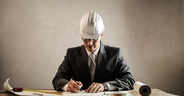 Hardhat - Professional architect working with draft in office