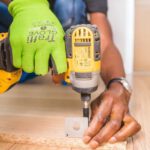 Construction - Person Using Dewalt Cordless Impact Driver on Brown Board