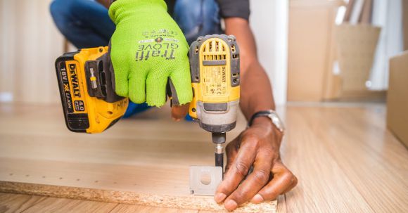 Construction - Person Using Dewalt Cordless Impact Driver on Brown Board