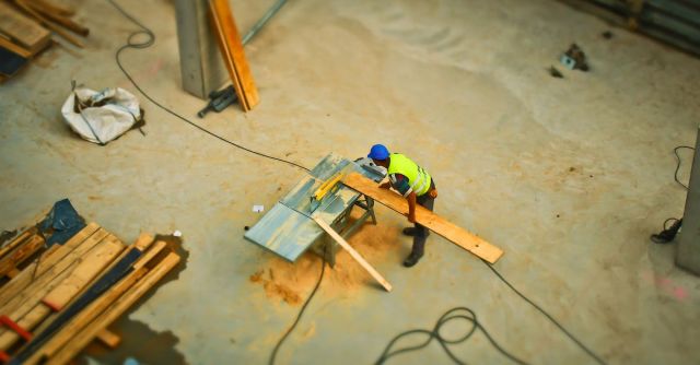 Builder - Person Cutting Wood on Table Saw during Daytime