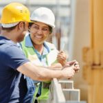 Builder - A Man and Woman Wearing Hard Hat While Talking