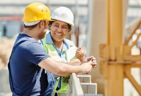 Builder - A Man and Woman Wearing Hard Hat While Talking