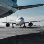 Construction Industry - Low angle of various airplanes parked on airfield against blue sky on sunny day