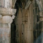 Masonry Wall - Interior of ancient stone masonry palace with arched passages and ornamental columns on shabby cement floor with ray of light