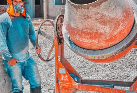 Concrete Mixers - Construction Worker Standing Beside A Concrete Mixer