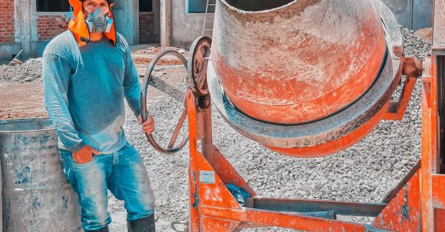 Concrete Mixers - Construction Worker Standing Beside A Concrete Mixer