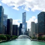 Сonstruction Crane - River Between Trees and City Skyscrapers