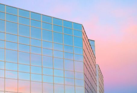 Skyscraper Construction - Exterior of contemporary building with glass mirrored walls located in city against colorful sky at sunrise time