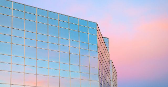 Skyscraper Construction - Exterior of contemporary building with glass mirrored walls located in city against colorful sky at sunrise time