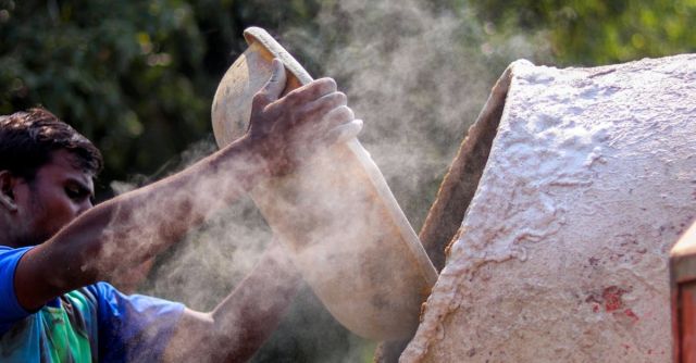Concrete Mixers - Ethnic man preparing cement for construction